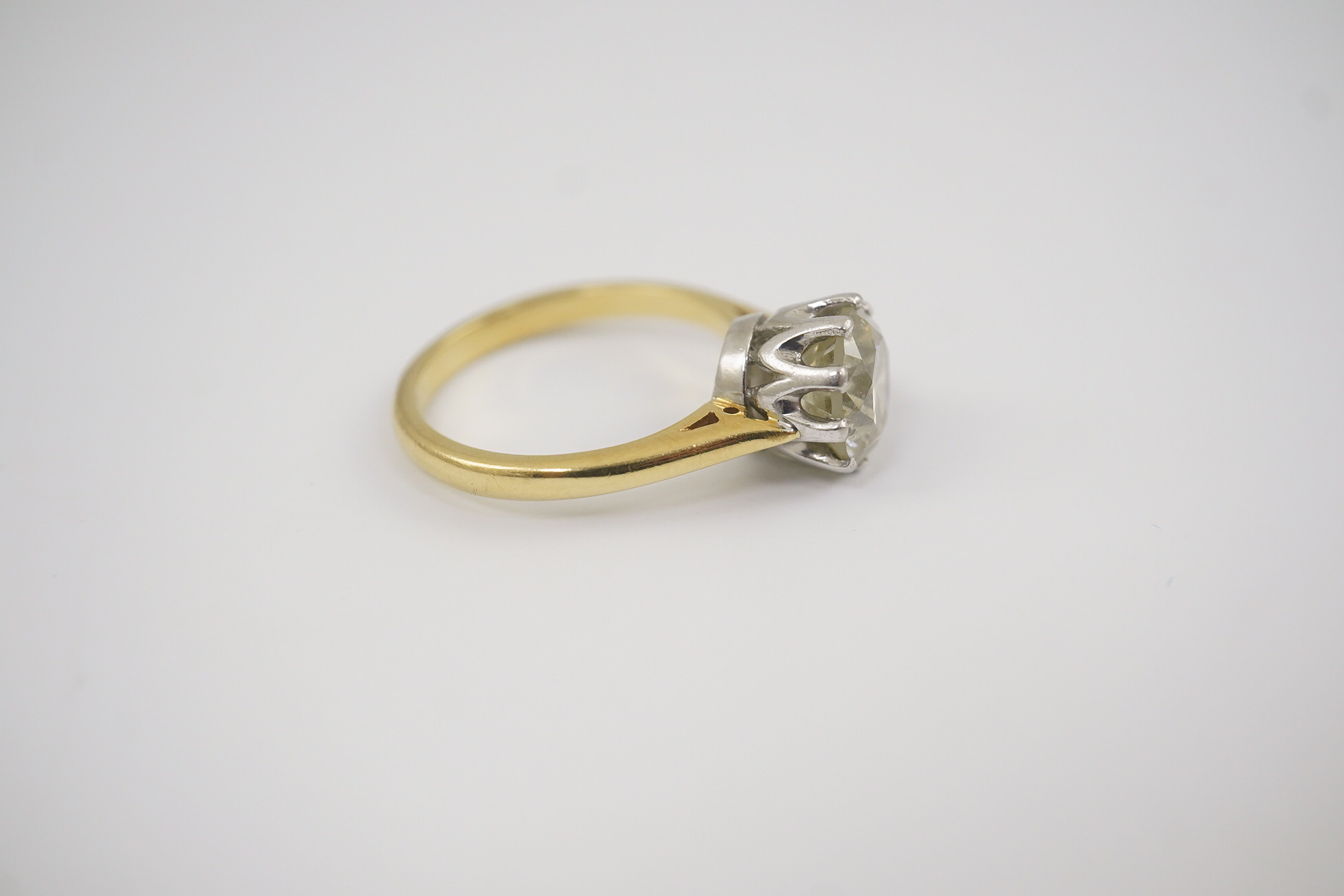 A modern 18ct gold and solitaire round cut diamond set ring